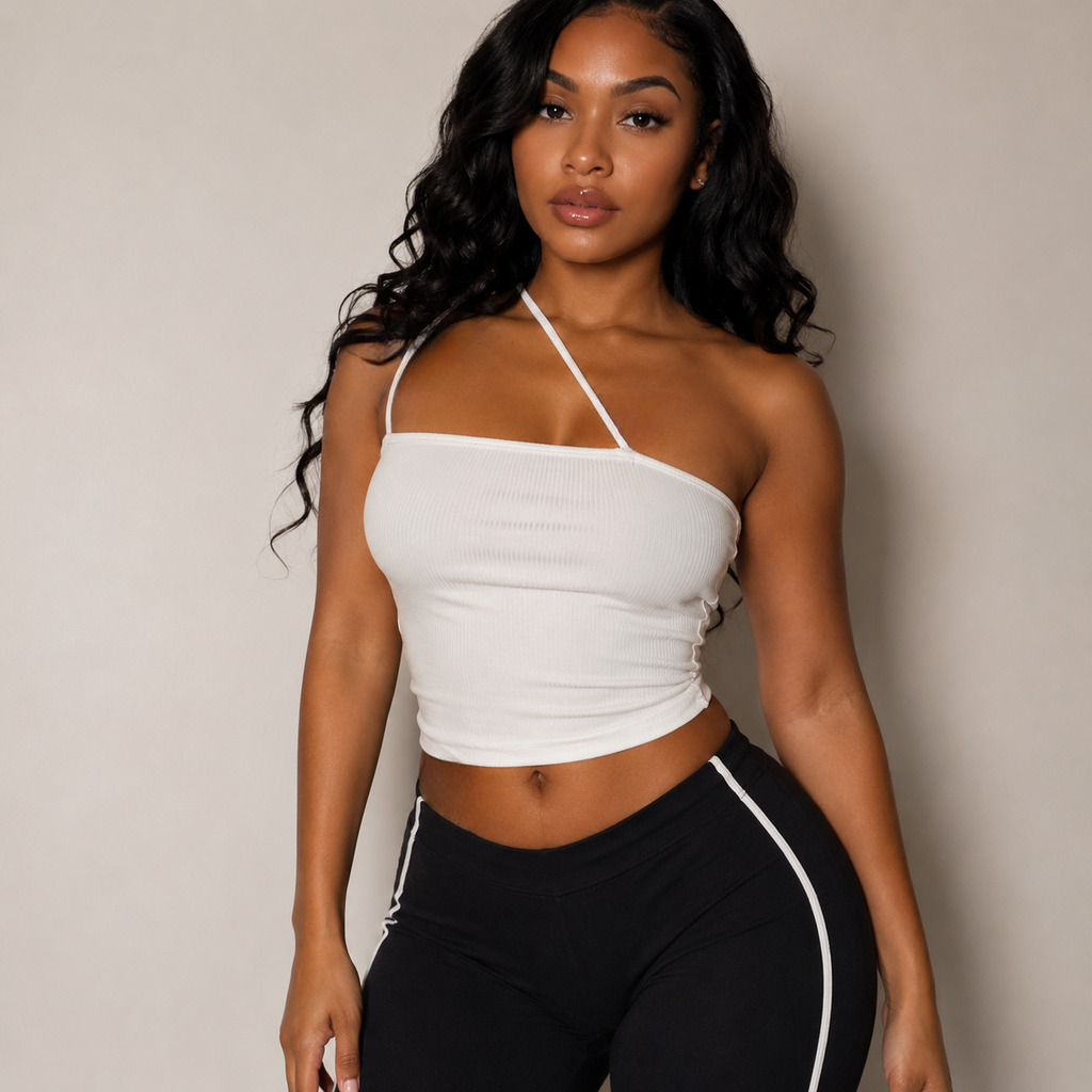 Woman wearing a white halter top and black pants with a white stripe against a neutral background