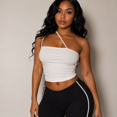 Woman wearing a white halter top and black pants with a white stripe against a neutral background