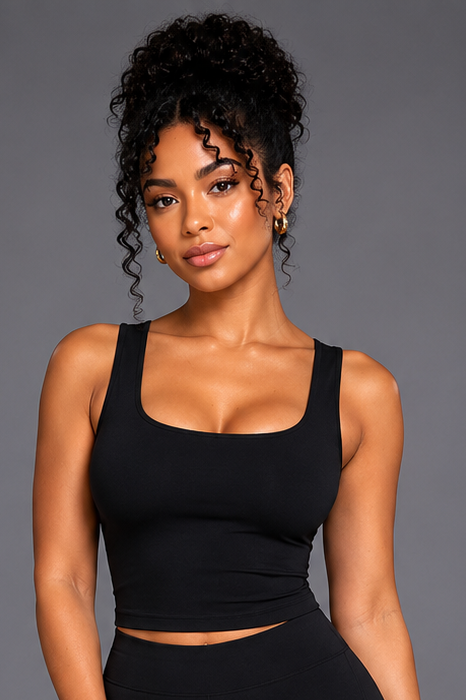 Woman wearing a black athletic outfit on a gray background