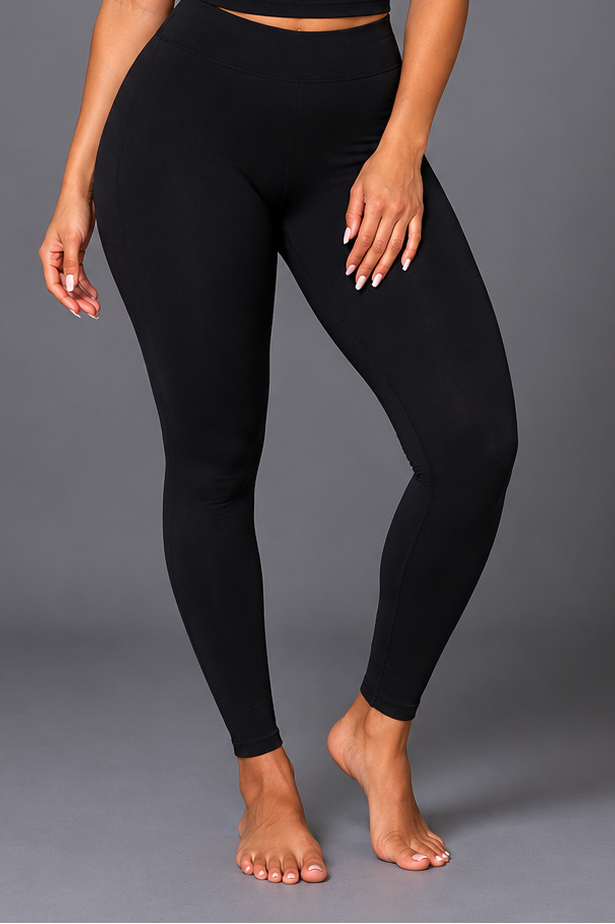 Person wearing black leggings on a gray background