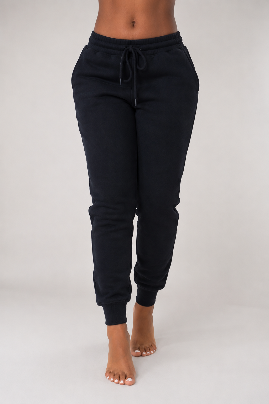 Black sweatpants worn by a person on a white background