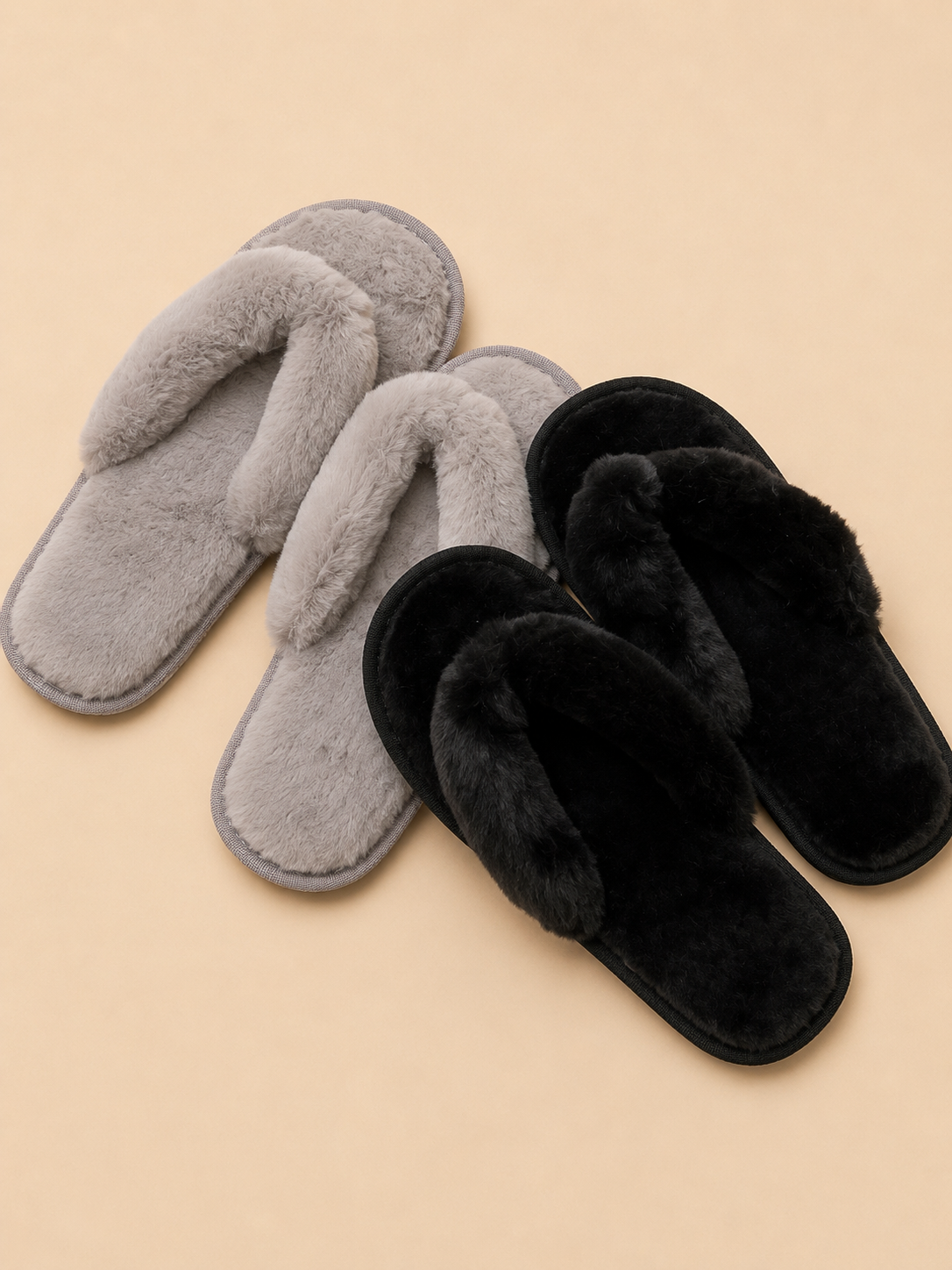 Pair of gray slippers and a pair of black slippers on a beige background