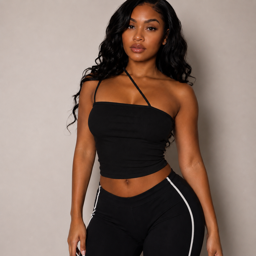 Woman wearing a black halter top and black pants with white stripes against a beige background