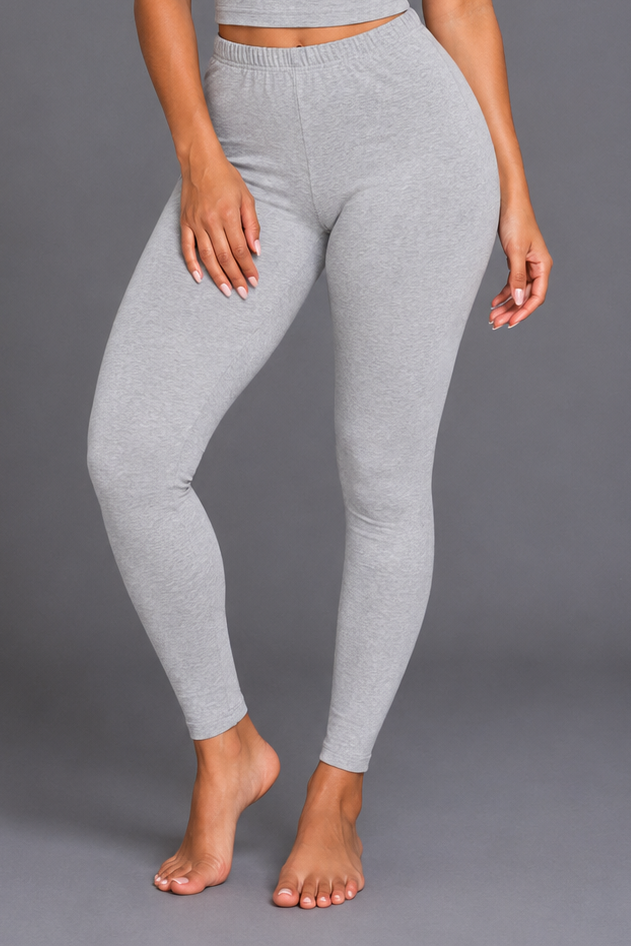 Woman wearing a gray athletic outfit on a gray background