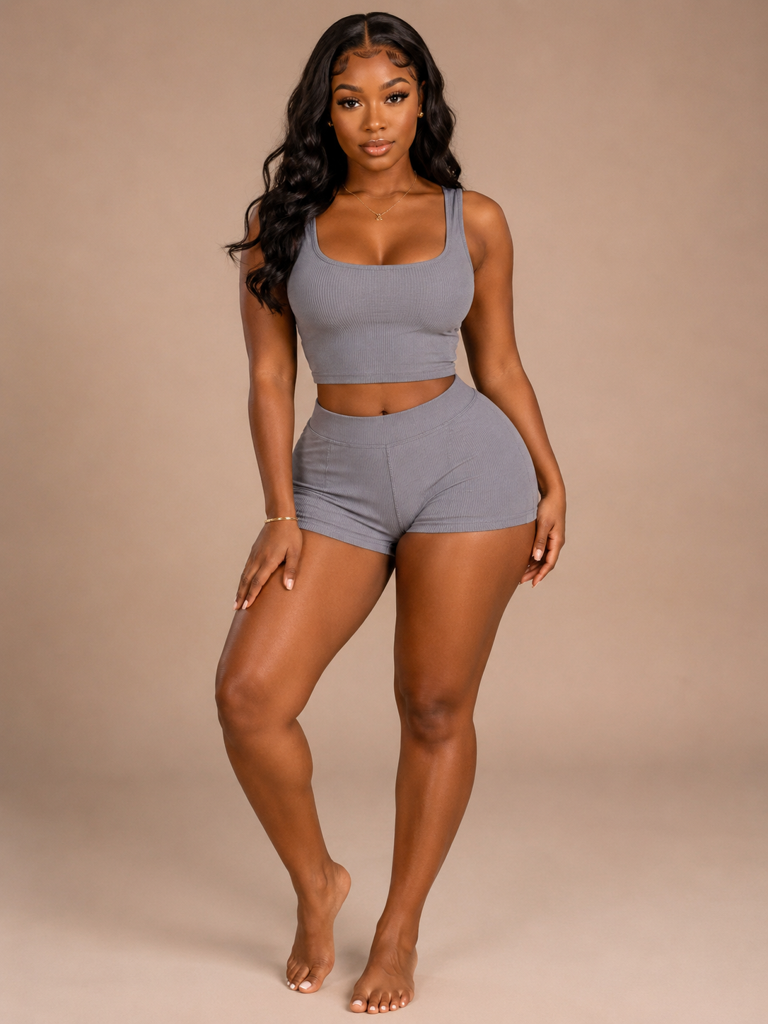 Woman wearing a gray athletic outfit on a beige background