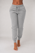 Gray sweatpants worn by a person on a plain background