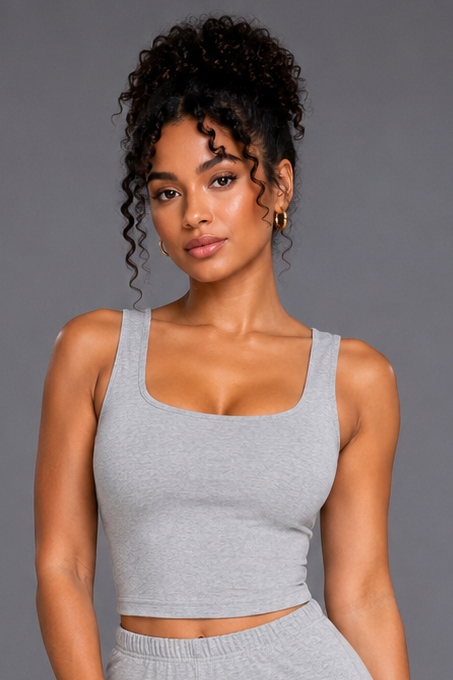 Woman wearing a gray athletic outfit on a gray background