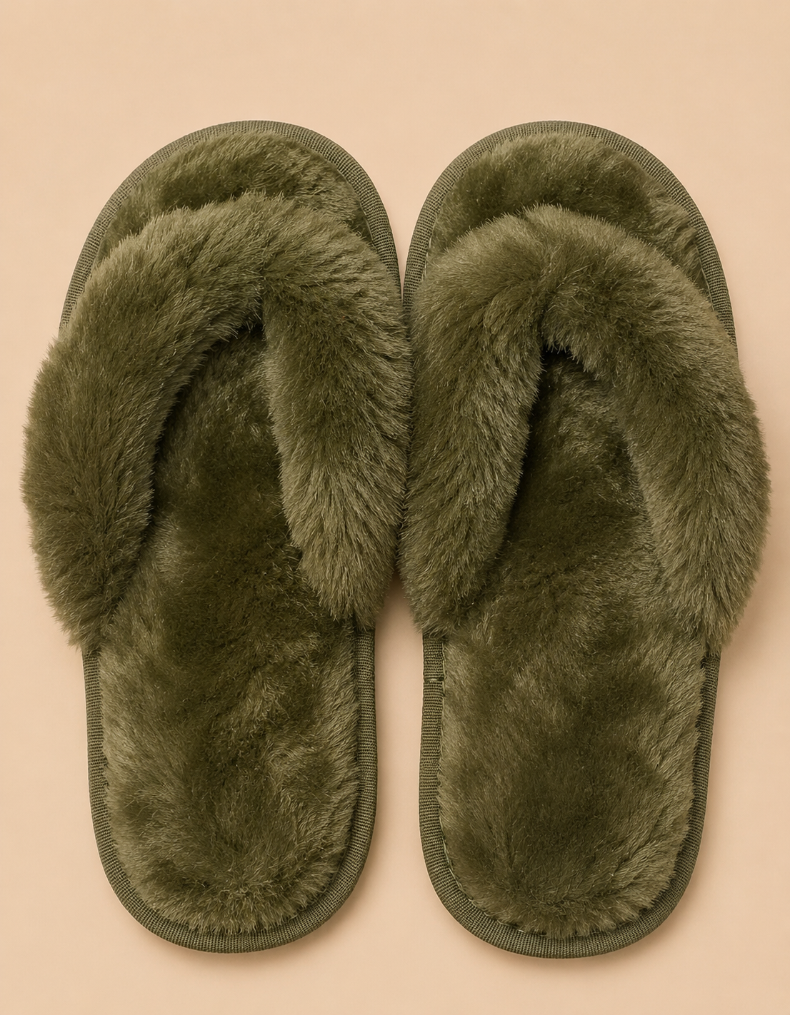 Pair of green fuzzy slippers on a beige background