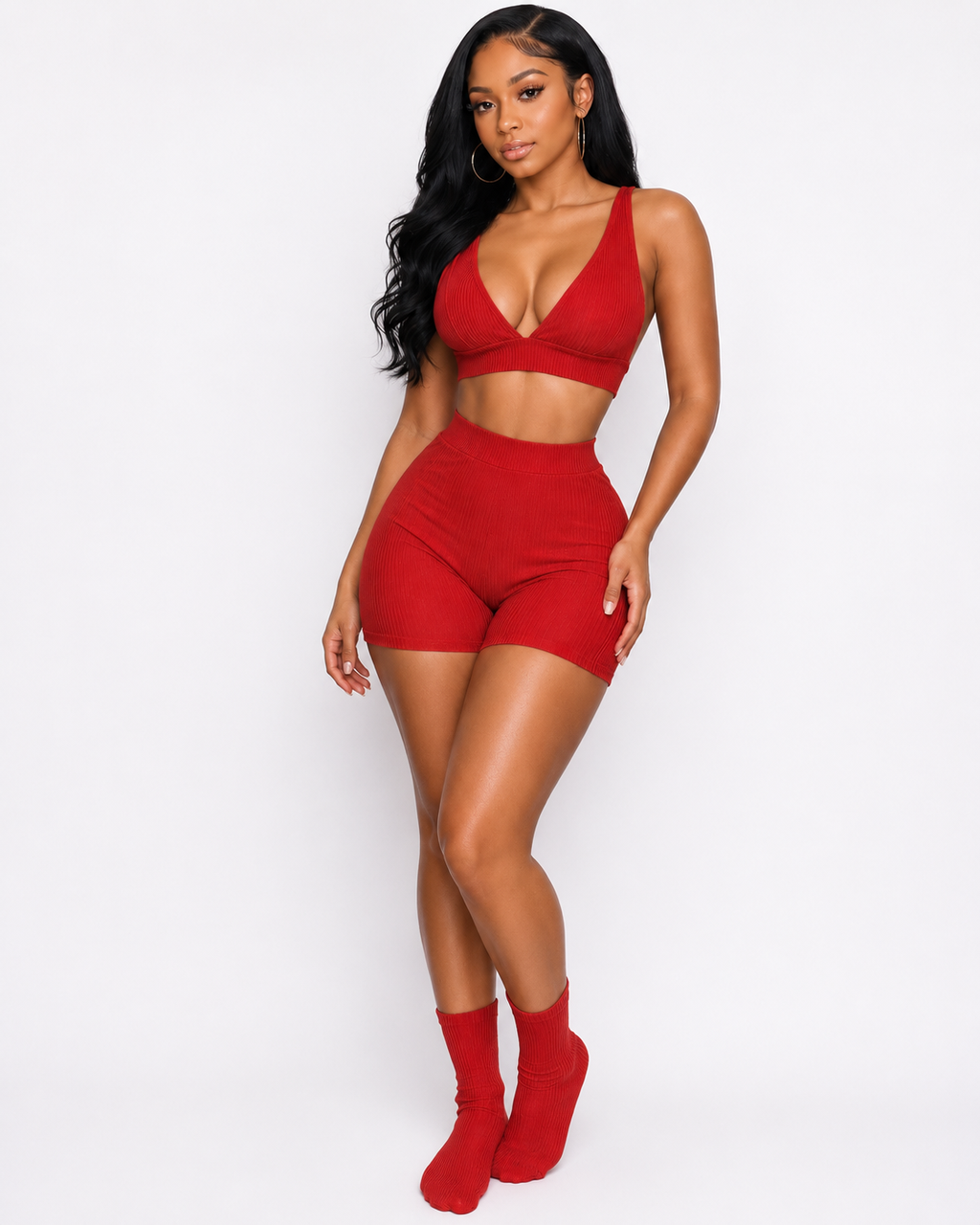 Woman wearing a red sports bra and shorts set on a white background